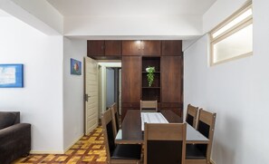 A dining area with a wooden table and chairs, a potted plant, and a view of a hallway. - Apt. w/ Balcony & Sea View 360m Beach Ety0024 (Balneário Camboriú)