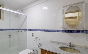 A bathroom with a glass shower enclosure, a toilet, a sink with a mirror above it, and blue-tiled accents on the walls. - Apt. w/ Balcony & Sea View 360m Beach Ety0024 (Balneário Camboriú)