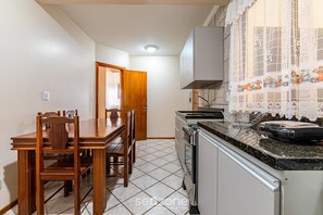 Une cuisine équipée d’une table et de chaises, d’une cuisinière et d’un évier.