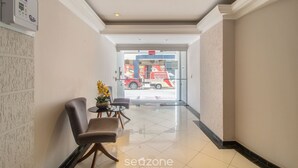 A hotel lobby with a reception desk, seating area, and a view of the street outside. - 3BR Apt w/ Balcony 100m From Beach Evz0601 (Balneário Camboriú)