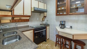 A kitchen with granite countertops, a stove, a sink, and wooden cabinets. - 3BR Apt w/ Balcony 100m From Beach Evz0601 (Balneário Camboriú)