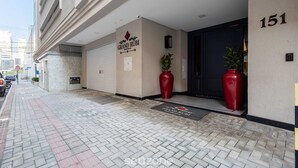 A hotel entrance with a sign reading "Grand Rubi Residences." - Modern and Fully Equipped Apartments Just Minutes From the sea at Meia Praia - GRI (Itapema)