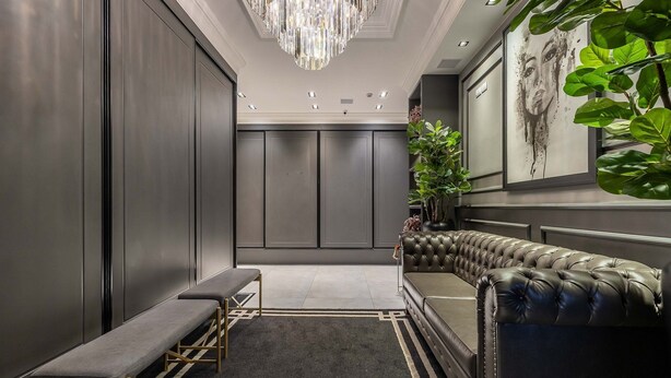 A modern lobby with a bench, a sofa, a chandelier, and a large plant. - Modern and Fully Equipped Apartments Just Minutes From the sea at Meia Praia - GRI (Itapema)