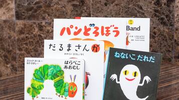 Kokoelma kirjoja, joissa on japaninkielistä tekstiä, aseteltuna puupinnalle.