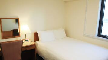 Una habitación de hotel con una cama, una mesita de noche con lámpara, una silla, un espejo y una ventana.
