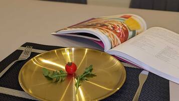A table with a gold plate, a fork, a knife, and an open magazine.