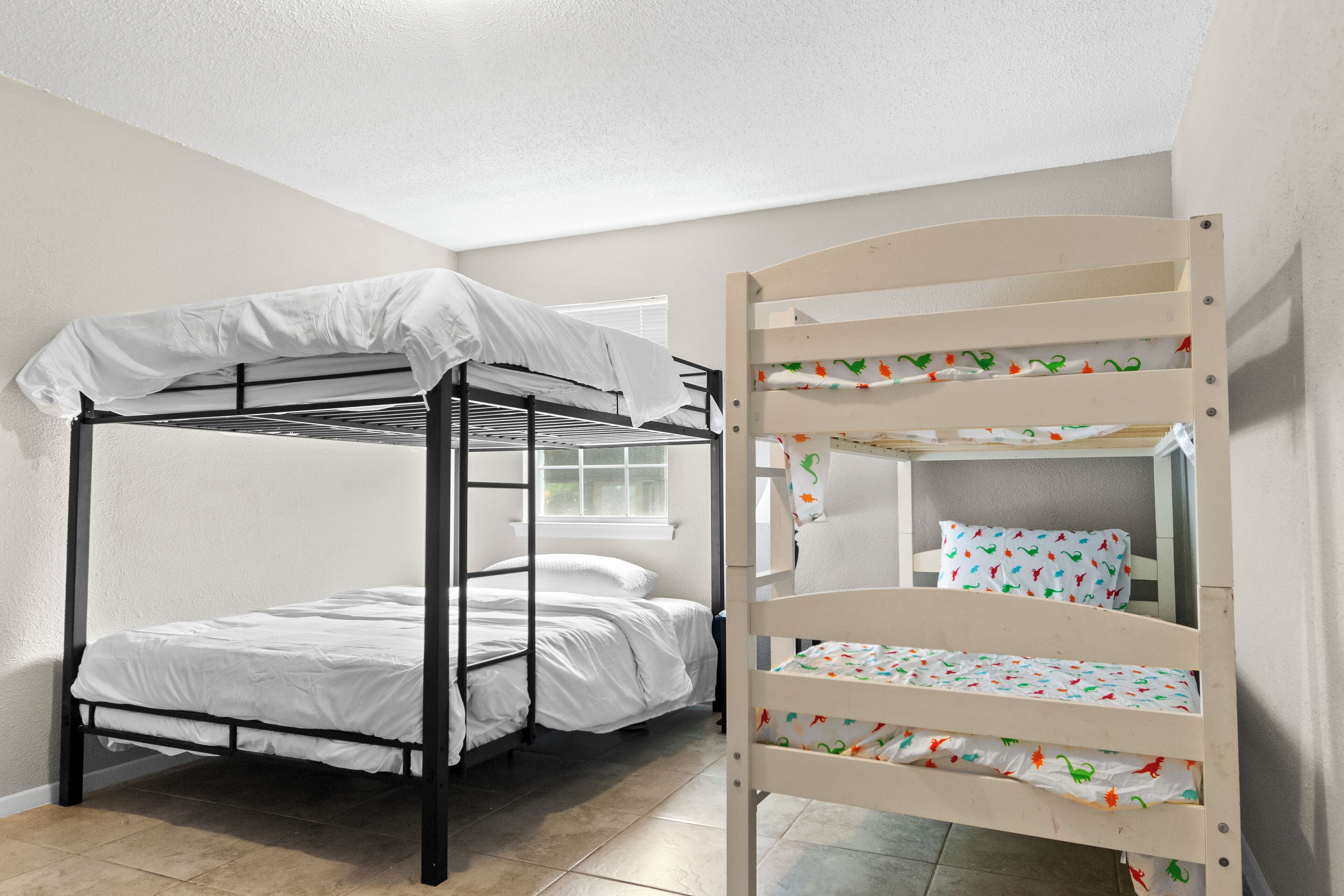 A bunk bed with a white canopy and a lower bunk with a colorful floral bedspread.