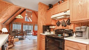 A kitchen with wooden cabinets, a stove, and a coffee maker.