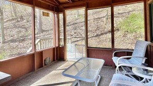 A cabin with a wooden ceiling, large windows, a table, and two chairs. - "Evergreen" Private, creek-side escape (Berkeley Springs)