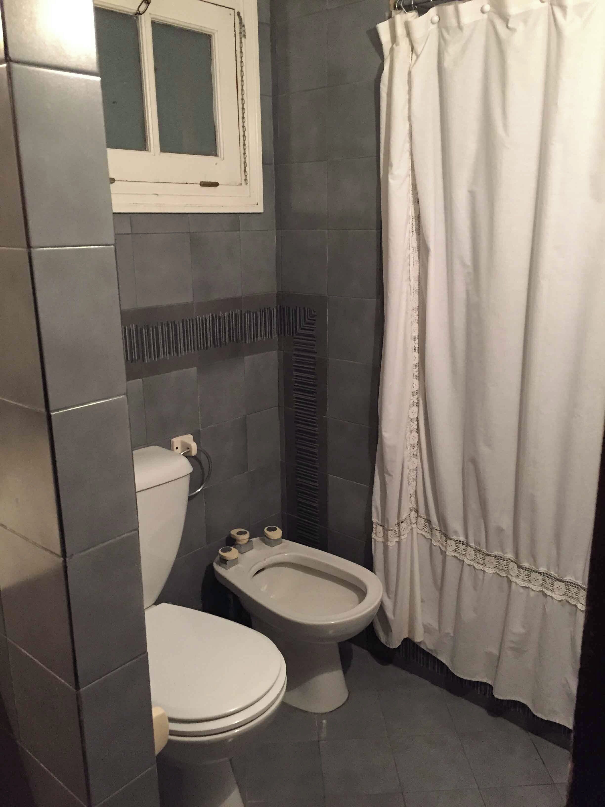 Un baño pequeño con inodoro, bidé y cortina de ducha.