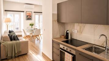 Una cucina moderna con forno a incasso, lavello e zona pranzo con tavolo e sedie.