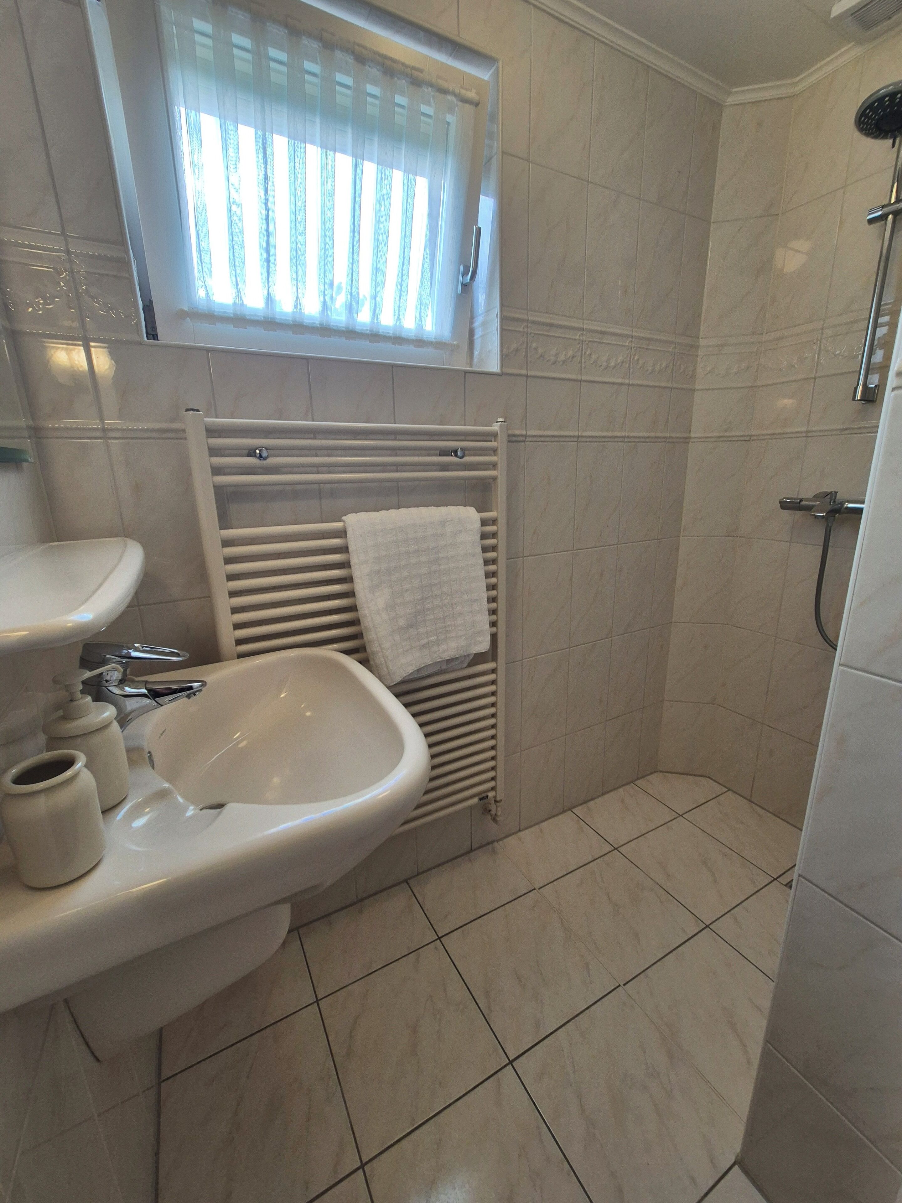 Een badkamer met een wastafel, toilet en douche.