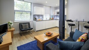 Un salon moderne avec un canapé, une table basse et un téléviseur.