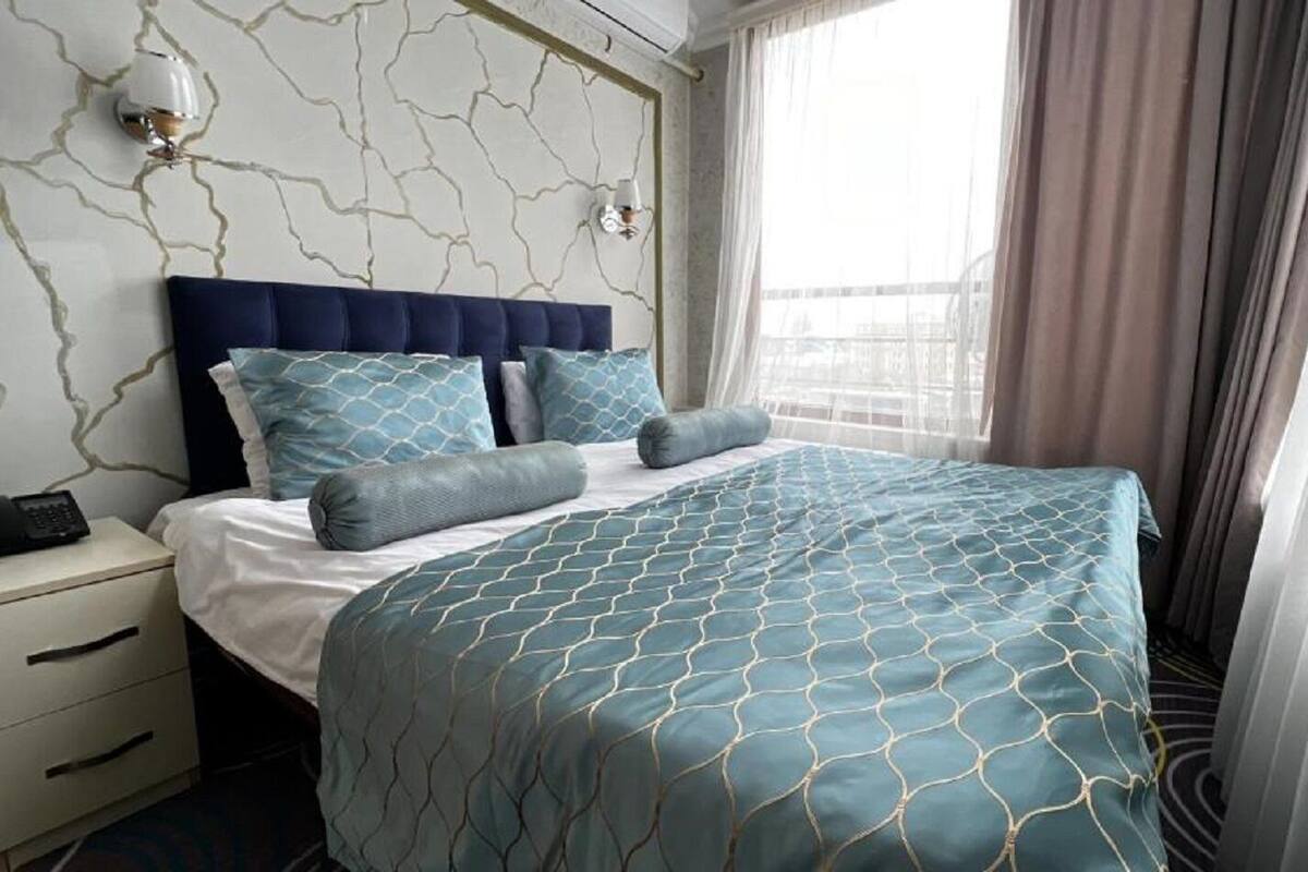 Une chambre d’hôtel avec un lit, une table de chevet et un téléphone.