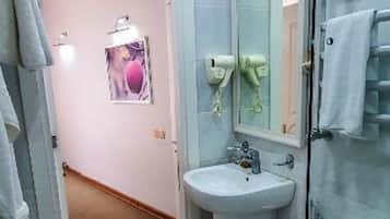Ein Badezimmer mit Toilette, Waschbecken und einer Duschkabine aus Glas.