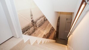 A staircase with a view of a historic building through a large poster. - GOLDEN SUITE (Venezia)