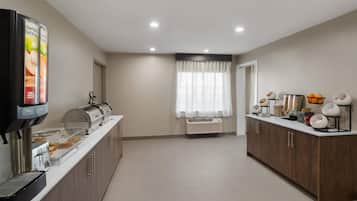 A modern kitchen with a coffee station, a toaster, and a refrigerator.