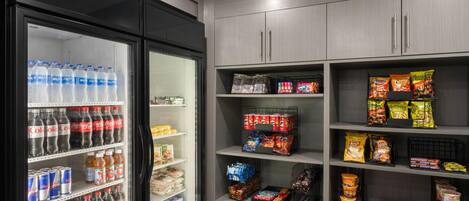 Un refrigerador lleno de bebidas y una despensa con aperitivos y productos envasados.