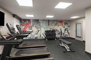 A gym with treadmills, weight benches, and dumbbells. - Wingate By Wyndham Jackson (Jackson)