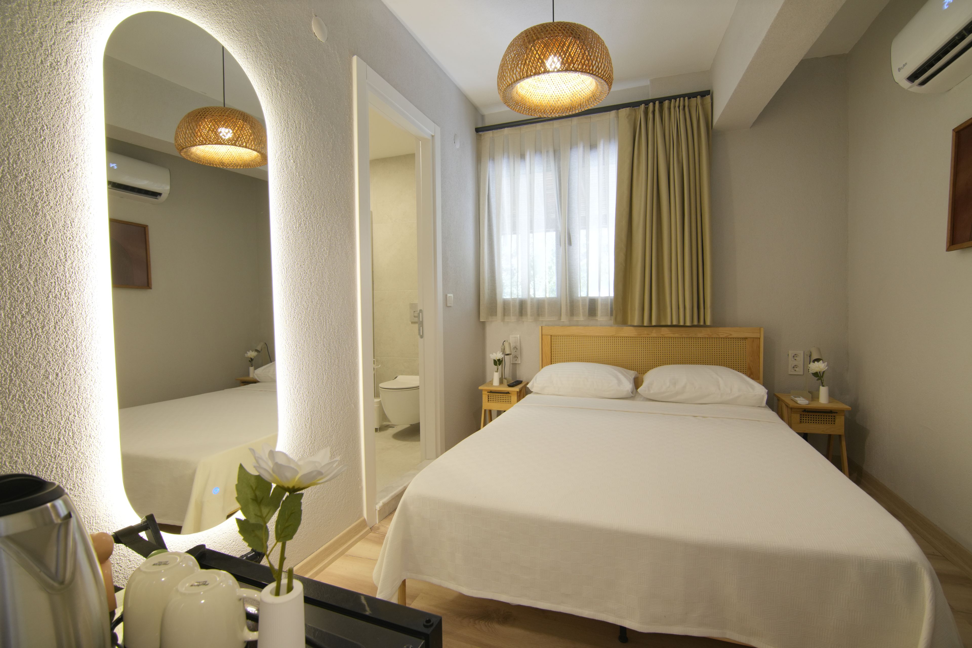 Habitación de hotel con una cama grande, un área de descanso con una mesa y sillas, un baño y vistas al exterior.