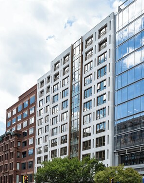 A modern multi-story building with a mix of brick and glass facades, featuring numerous windows and balconies. - ROOST White House (Washington)