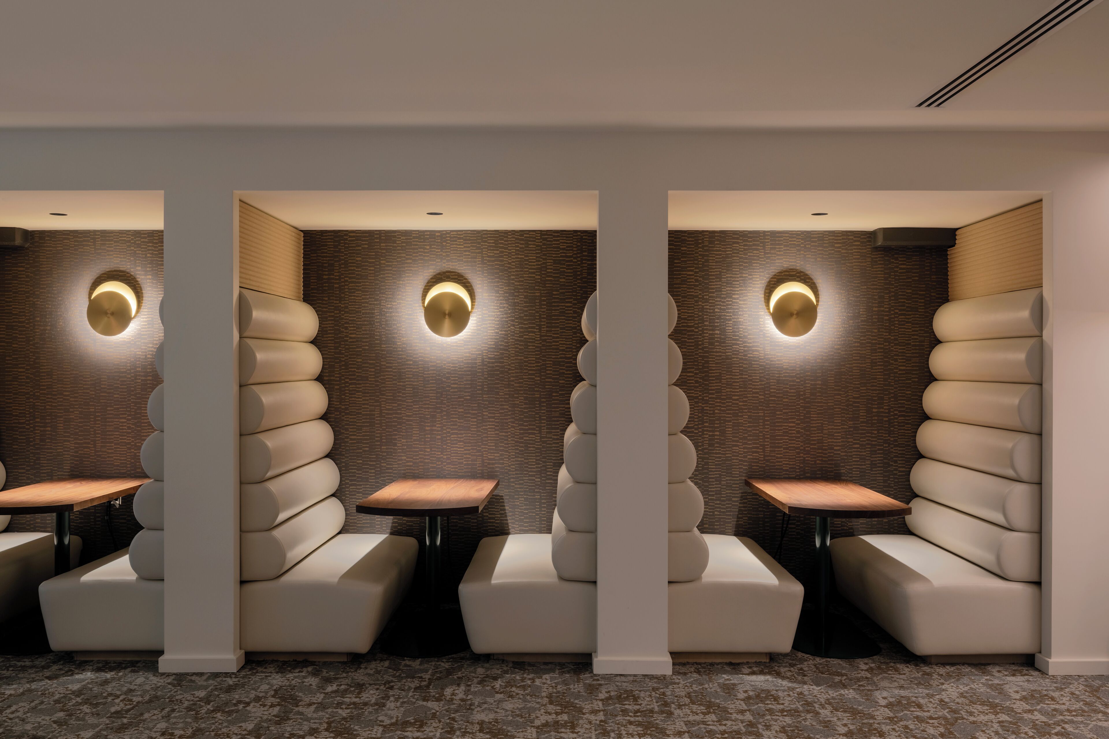 A modern, minimalist lounge area with tiered seating and built-in lighting.