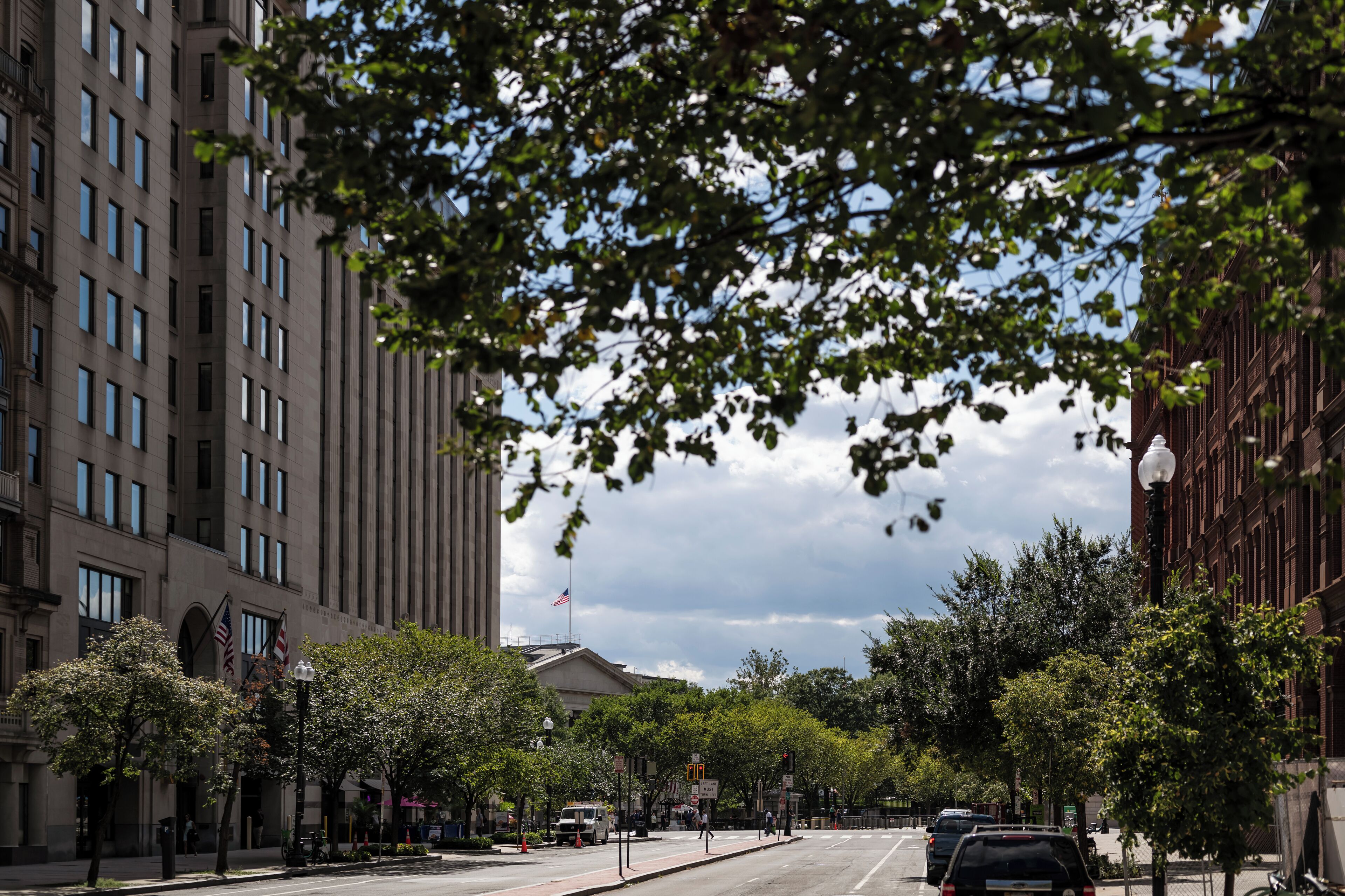 A street view with buildings, trees, and a clear sky.