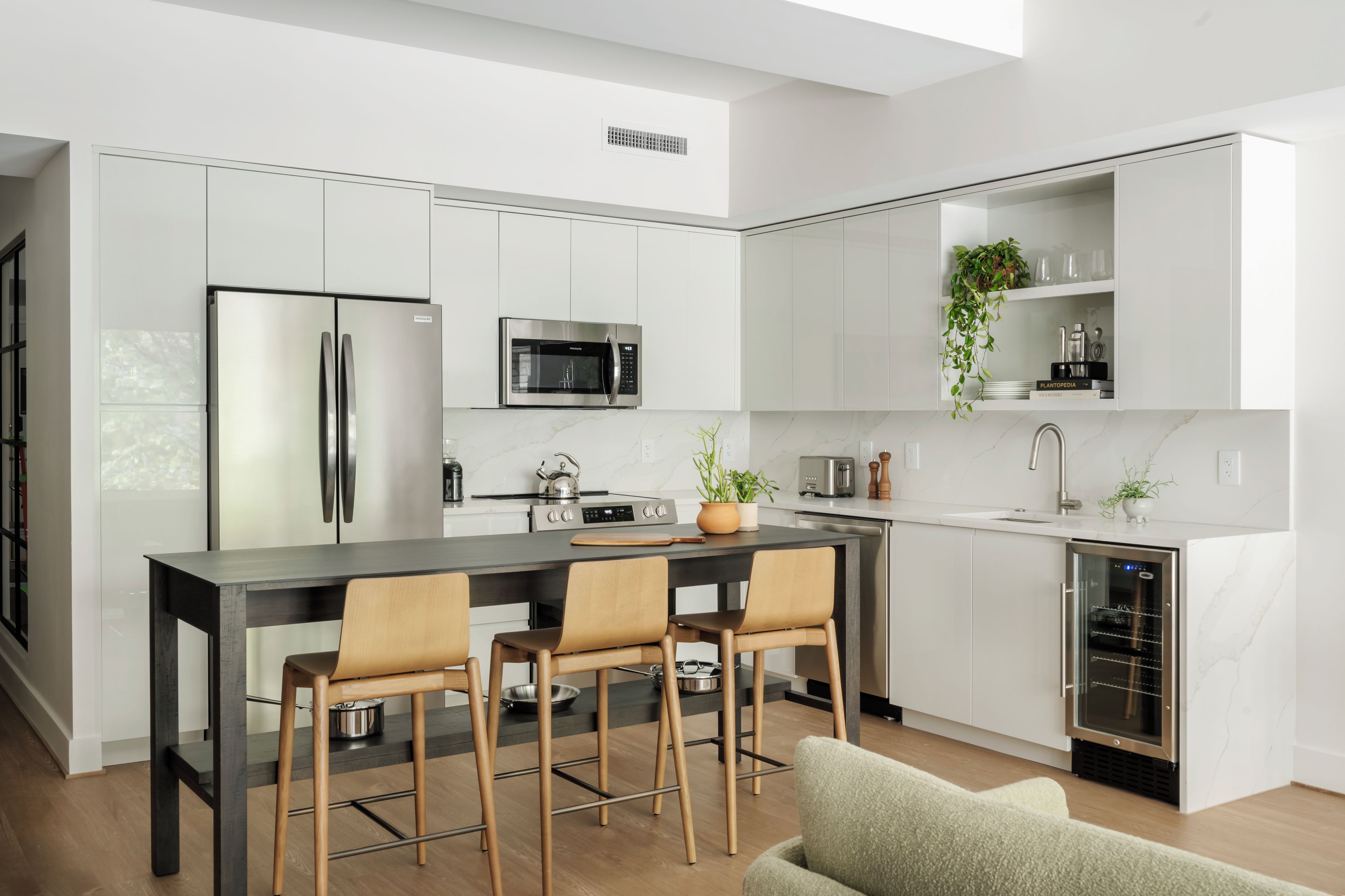 A modern kitchen with a central island, stainless steel appliances, and a minimalist design.