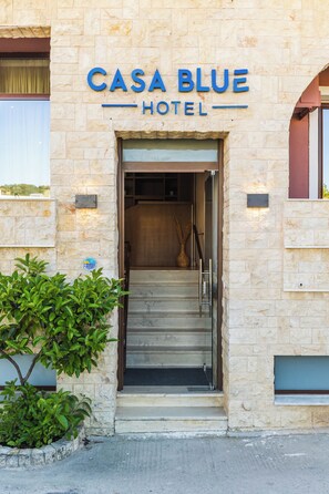 The entrance to Casa Blue Hotel with a stone facade and a sign above the door. - Casa Blue Hotel (Skiathos)