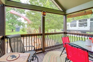 A covered patio with a table, chairs, and a view of a backyard and a parked RV. - 1 Mi to Tank Town USA: Tiny Home w/ Pool Access! (Morganton)
