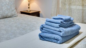 A neatly made bed with a stack of folded towels on the side. - 5 Mi to Cherry Grove Beach: Dog-Friendly Condo! (Little River)