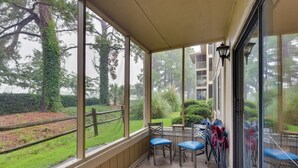 A covered patio with a view of a landscaped garden, including a wooden fence and a building in the background. - 5 Mi to Cherry Grove Beach: Dog-Friendly Condo! (Little River)
