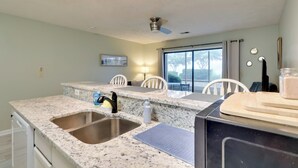 A kitchen with granite countertops, a double sink, and a ceiling fan. - 5 Mi to Cherry Grove Beach: Dog-Friendly Condo! (Little River)