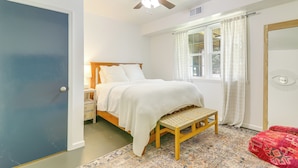 A bedroom with a bed, a wooden bench, a window with curtains, and a ceiling fan. - Athens Apartment for Saturdays Between the Hedges (Athens)