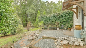 A garden with a gravel path, wooden steps, and a bench. There are potted plants and a large pot near a building. - Athens Apartment for Saturdays Between the Hedges (Athens)