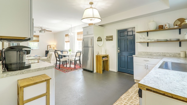 A modern kitchen with a coffee maker, refrigerator, and dining area. - Athens Apartment for Saturdays Between the Hedges (Athens)