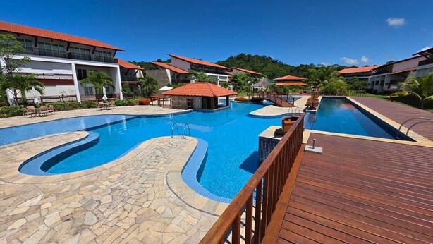 A resort with multiple swimming pools, a wooden deck, and buildings with red roofs. - Club Meridional Carneiros 01PS  byLP (Tamandaré)