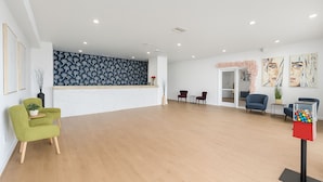 A spacious lobby with a wooden floor, a reception desk, and several seating areas. - Unno Boutique Hotel  (Kissimmee)