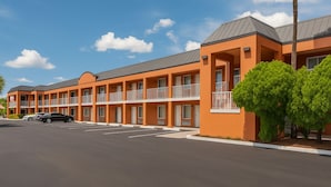 A multi-story motel with a row of rooms, each with a balcony and a window. - Unno Boutique Hotel  (Kissimmee)