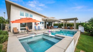 A modern house with a swimming pool, outdoor furniture, and a covered patio area.