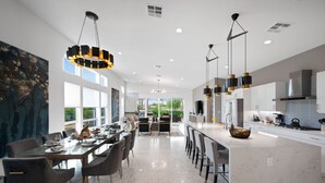 A modern kitchen with a central island, pendant lighting, and a view to the outdoors.