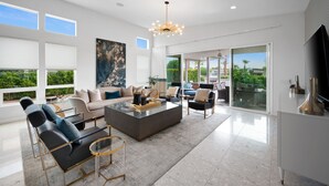 A spacious living room with a modern sofa set, a coffee table, and a large painting.