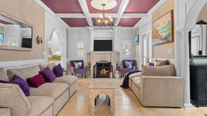 A spacious living room with a fireplace, two sofas, a coffee table, and a television.