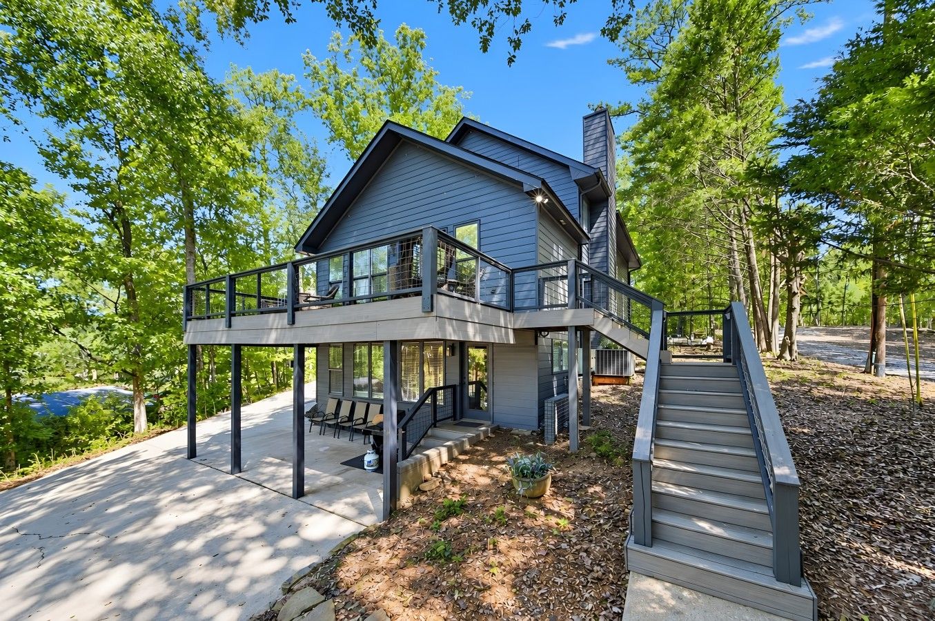 A modern two-story house with a covered porch, a staircase, and a driveway.