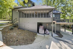 A modern house with a covered porch, a small deck, and a landscaped yard.
