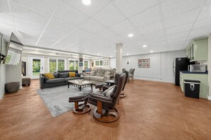A spacious living area with a sofa, chairs, and a coffee table.