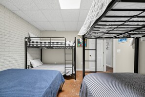 Une chambre de dortoir avec des lits superposés, une porte et une pancarte indiquant le numéro de la chambre.