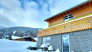 Un bâtiment à deux étages doté d’un balcon en bois et d’une façade en pierre.