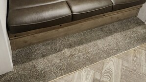 A brown leather sofa with a wooden base and a carpeted floor. - Nature Lover's 2-Bedroom RV Escape (Hamilton)