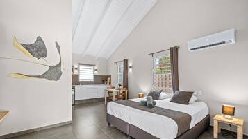 Une chambre à coucher moderne avec un grand lit, une table de chevet, une commode et une fenêtre avec des rideaux.
